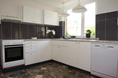 uma cozinha com armários brancos e electrodomésticos brancos em Vakantiewoning Oudsbergen em Opglabbeek