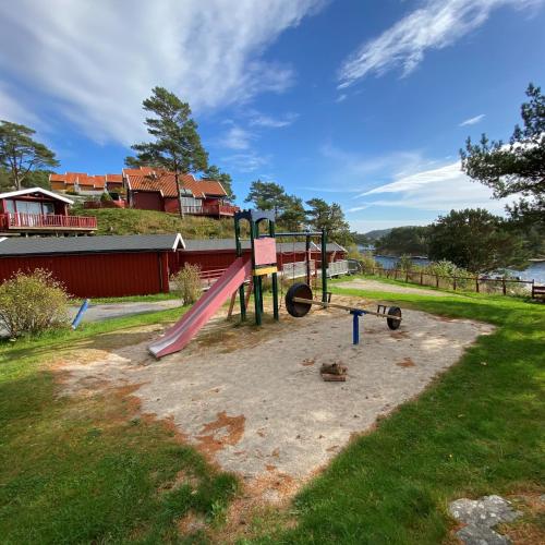 a playground with a pink slide in the grass at Tregde Ferie in Mandal