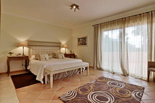 韋爾都勒博的住宿－Villa Vale Do Lobo 176 - 4 Bedroom villa - Great pool area - WiFi and Air conditioning，一间卧室设有一张床和一个大窗户