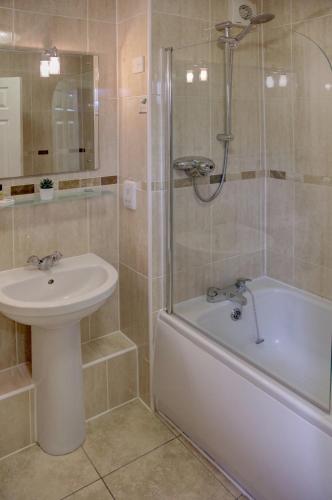 a bathroom with a sink and a tub and a shower at Best Western Plus West Retford Hotel in Retford
