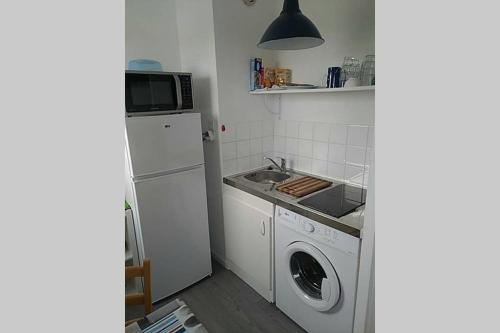 une cuisine avec un évier et une machine à laver dans l'établissement Studio Bord de Mer, à Saint-Jean-de-Monts