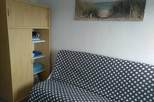 - un canapé-lit à la polka dans un salon avec une armoire dans l'établissement Studio Bord de Mer, à Saint-Jean-de-Monts
