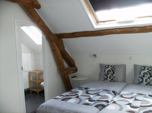 1 dormitorio con 1 cama con tragaluz en Bed op de Reth, en Baarle-Nassau