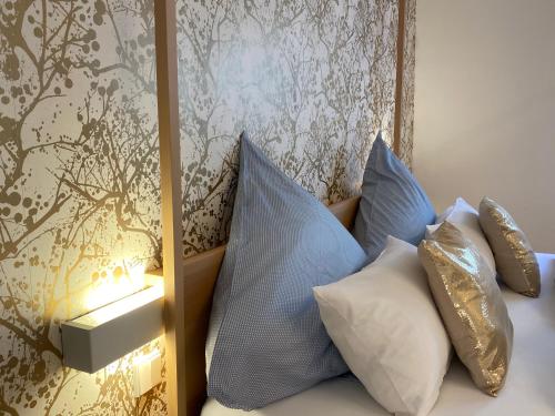 un letto con cuscini bianchi e blu accanto a un muro di Puro-Design-Apartment Deluxe - very central a Monaco