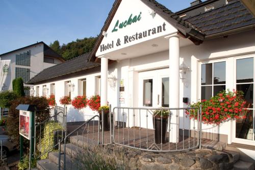 a white building with flowers in front of it at Luckai Hotel & Restaurant Inhaber Dennis Burmann in Freienohl