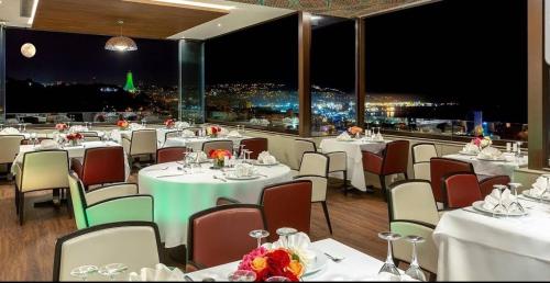 a restaurant with white tables and chairs with a view at AZ Hôtels Kouba in Alger