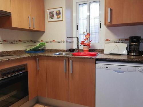 a kitchen with wooden cabinets and a sink at Joanet Guarda turismo familiar en plena naturaleza in La Guardiola
