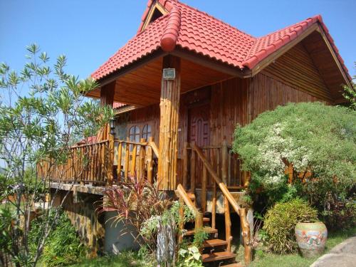 a wooden house with a porch and a deck at ภูน้ำทิพย์ รีสอร์ท in Ban Huai Phai