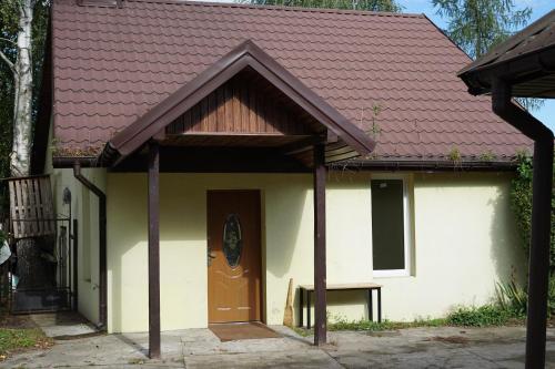 een huis met een rood dak en een deur bij Domek K2 - Niezależny 5 osobowy - NoclegiGrodziskPL 792-535-535 in Grodzisk Mazowiecki