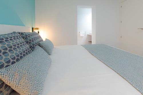 a bedroom with a bed and pillows on it at ABAL Apartments - Barrio in Alicante