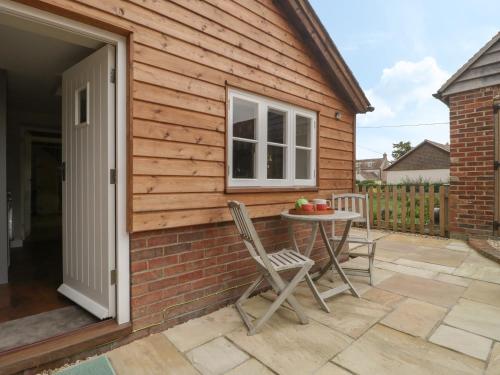 a patio with a table and chairs next to a building at The Nest at the Round House in Warminster