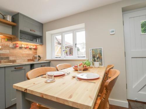 a kitchen with a wooden table and chairs at The Nest at the Round House in Warminster