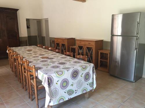 uma cozinha com uma mesa e um frigorífico em Gite Sainte Octime em Sardan