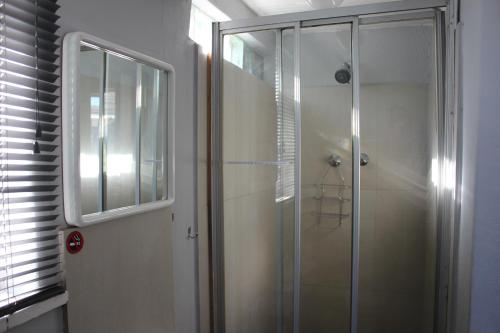 a bathroom with a shower with a glass door at 25 on Fitzpatrick in Parow