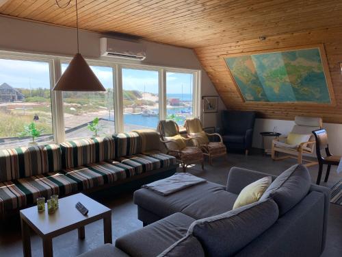a living room with couches and a large window at Pakhuset Anholt in Anholt
