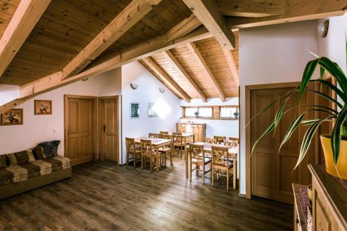 a dining room with tables and chairs and a couch at Roubenka u Huvarů in Tachov