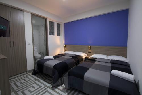 金巴亚PARIS. HOTEL的房间里有两张床，墙壁是蓝色的