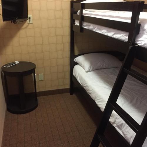 a room with two bunk beds and a table at Inn on Prince Hotel and Conference Centre Truro in Truro