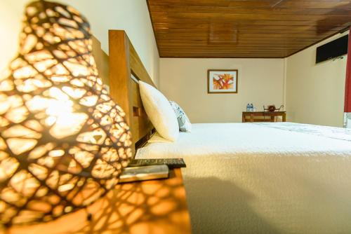 a bedroom with a white bed with a wooden ceiling at Hotel Flor De Sarta in León