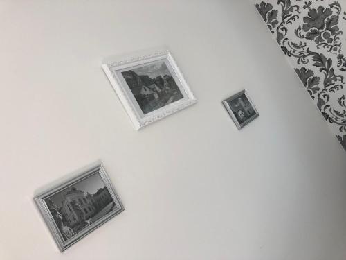 three framed photographs on a white wall at Városi Idill in Veszprém