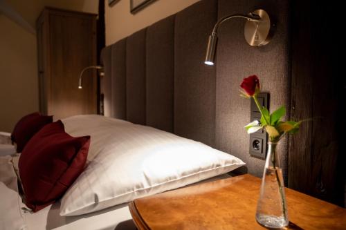 a bedroom with a bed with a vase of flowers on a table at Pension U Lilie in Prague