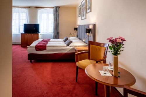 プラハにあるペンション ウ リリーのベッドとテーブルが備わるホテルルームです。