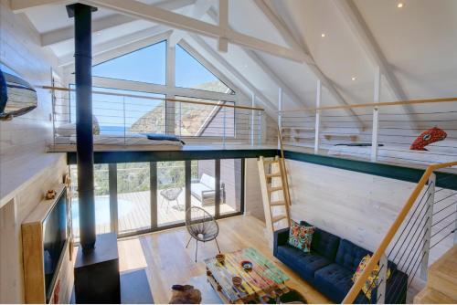 an attic room with a blue couch and bunk beds at Earth Wind and Ocean 8 in George