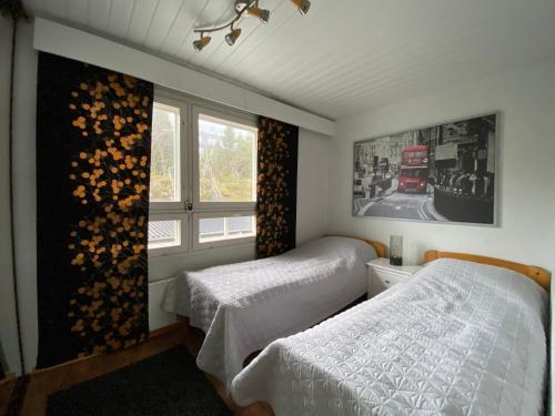 a bedroom with two twin beds and a window at Tunturi Panorama Iso-Syöte in Syöte