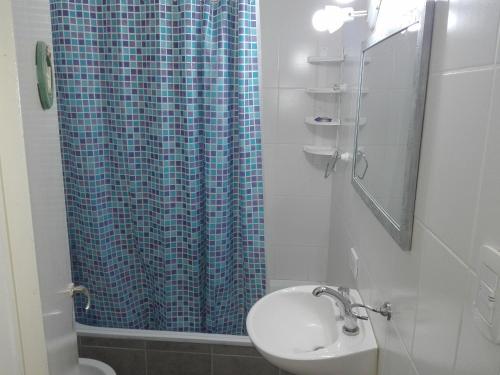 baño con cortina de ducha azul y lavamanos en MONOambienteporDIA en Bahía Blanca