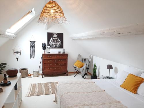 a white bedroom with a bed and a dresser at Jardin de Mathilde in Nangis