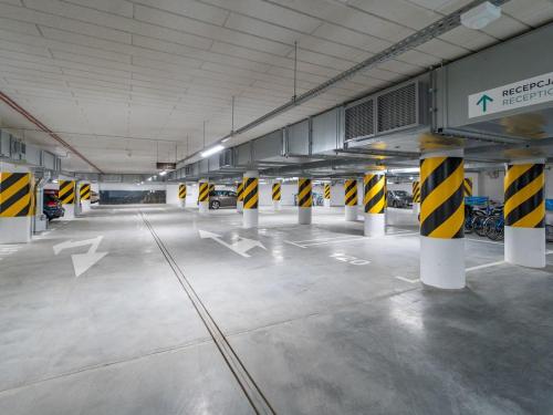 an empty parking lot with yellow and black barricades in a parking garage at Seaside - Apartamenty KOMFORT, widok na morze, Parking in Kołobrzeg
