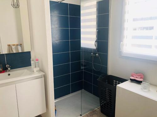 a bathroom with a shower with blue tiles at Appart familial à 800 m de la plage ! in Argelès-sur-Mer