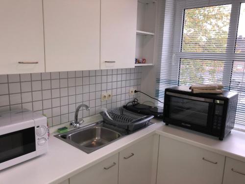 cocina con fregadero y microondas en Lindenstraße, en Belm