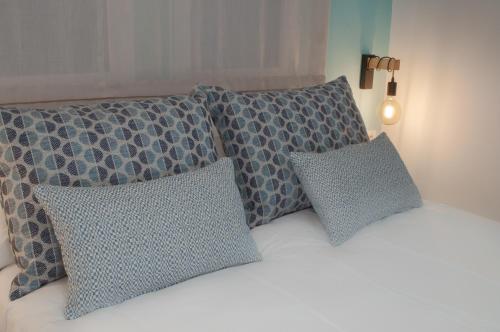 a bed with four pillows on top of it at ABAL Apartments - Barrio in Alicante