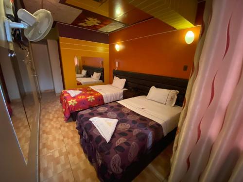 a hotel room with two beds and a mirror at Hotel Manantial No,001 in Lima