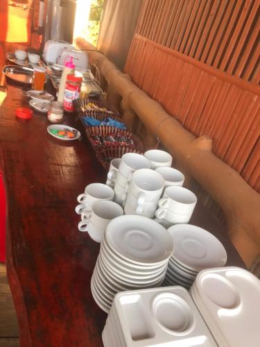 a long line of white plates and cups on a table at ภูน้ำทิพย์ รีสอร์ท in Ban Huai Phai