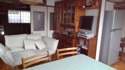 a living room with a couch and a tv at OTERA HOUSE 瑞　TAMA in Osaka