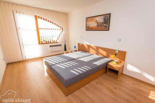 ein Schlafzimmer mit einem großen Bett und einem großen Fenster in der Unterkunft Opilé Sklepy in Velké Pavlovice