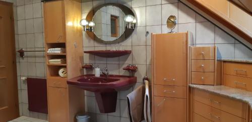 baño con lavabo púrpura y espejo en Wein- und Weitblick, en Gleinstätten