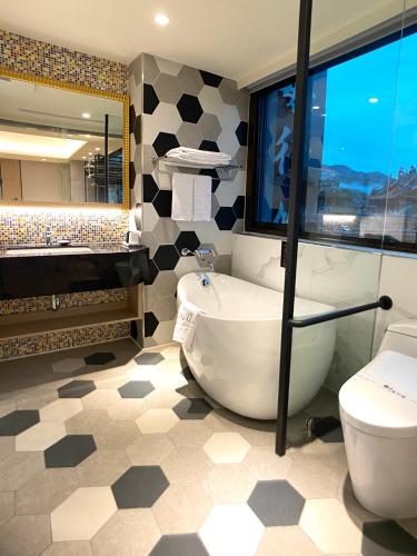 a bathroom with a tub and a toilet at Cai Mei Hotel in Dahu
