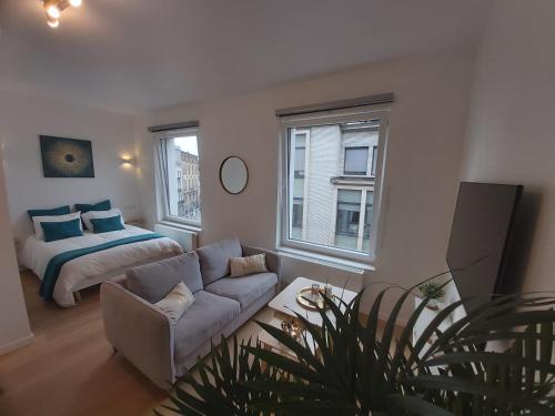 a living room with a couch and a bed at Logement luxueux dans le coeur de Bruxelles in Brussels