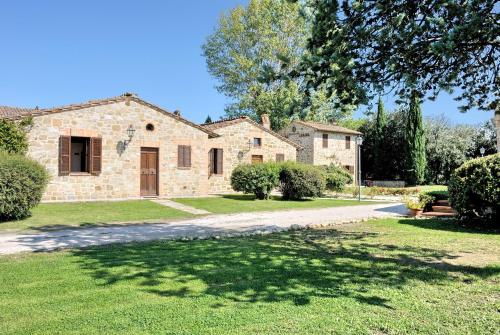 a large stone house with a large yard at I Casali Della Ghisleria in Ospedalicchio