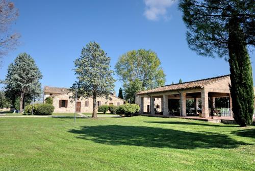 a house with a large yard with a tree at I Casali Della Ghisleria in Ospedalicchio