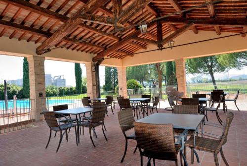 a patio with tables and chairs and a pool at I Casali Della Ghisleria in Ospedalicchio