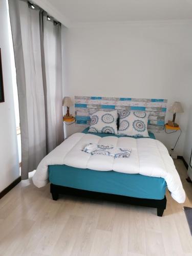 a bedroom with a blue and white bed with two lamps at Le Château du Bonheur, Piscine, Sauna et Jacuzzi in Le Loreur