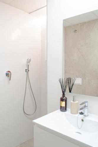 a white bathroom with a shower and a sink at ABAL Apartments - Barrio in Alicante