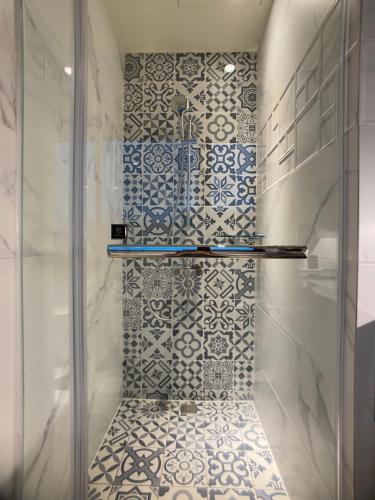 a bathroom with a shower with blue and white tiles at Cai Mei Hotel in Dahu