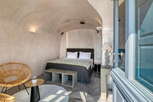 a bedroom with a bed and a table in a room at Nostos Apartments in Oia