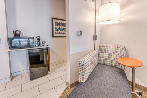 a room with a couch and a table and a microwave at Holiday Inn Express & Suites - Rantoul by IHG in Rantoul