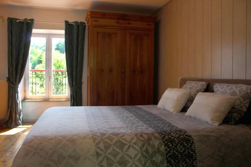 ein Schlafzimmer mit einem großen Bett und einem Fenster in der Unterkunft Moulin Pont Vieux Chambres d'hôtes in Mortagne-sur-Sèvre